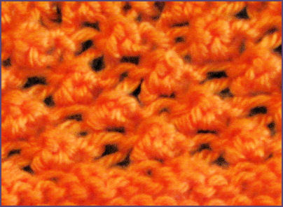 closeup of trinity stitch in orange yarn