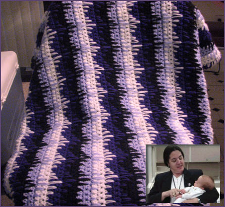 Purple striped afghan with photo of woman holding baby inset into the corner