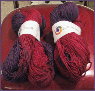 two hanks of yarn in purple and raspberry colorway