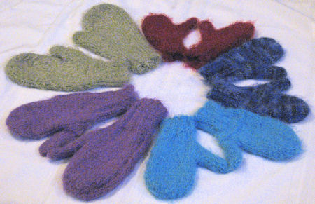 hand knit mittens in various colors and sizes, arranged in a circle