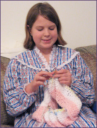 Diana, knitting a garter stitch striped baby blanket