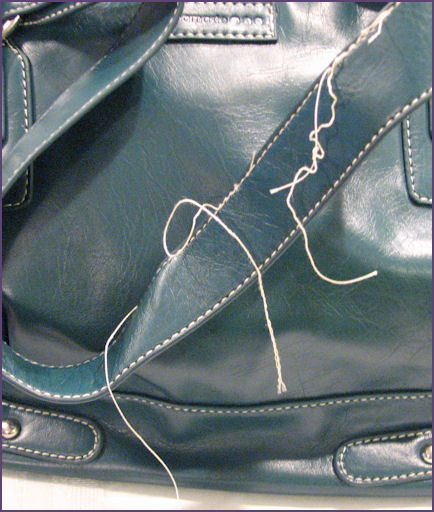 closeup of bag handles showing excess threads
