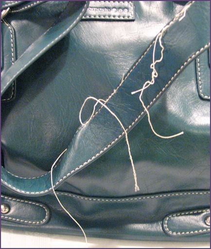closeup of bag handles showing excess threads closeup of bag handles showing excess threads