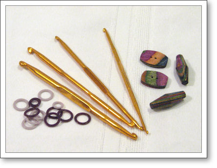 stitch markers, double-ended crochet hooks, and colorful wooden buttons