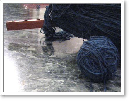 navy blue silk yarn being balled up from a swift