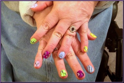 fingernails painted in various colors with black and white line designs