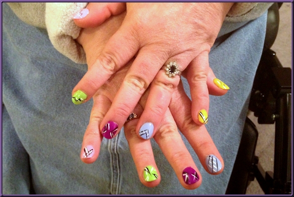 fingernails painted in various colors with black and white line designs