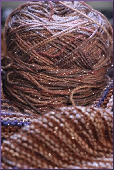 leftover ball of grey yarn resting on the shawl in progress