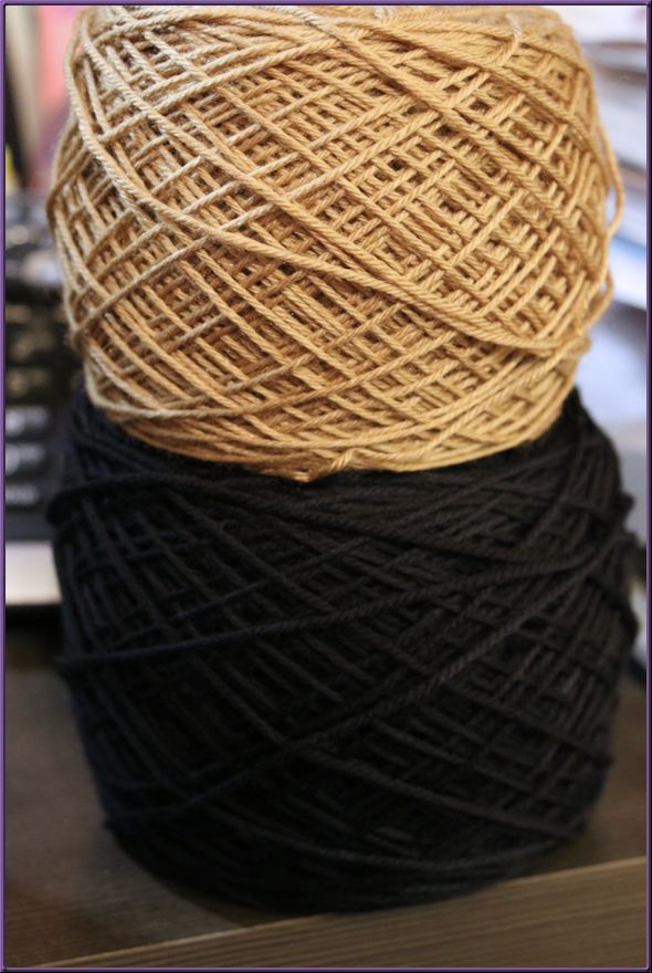 Two yarn balls, one dark green and one tan