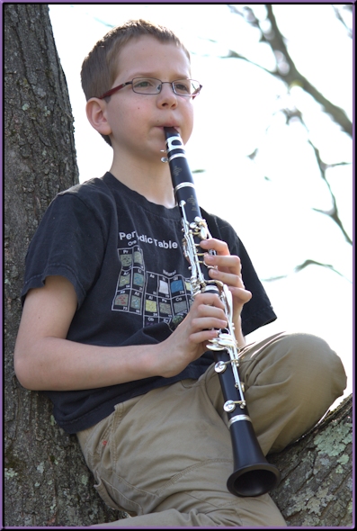 Steven, playing clarinet while sitting in his favorite tree.